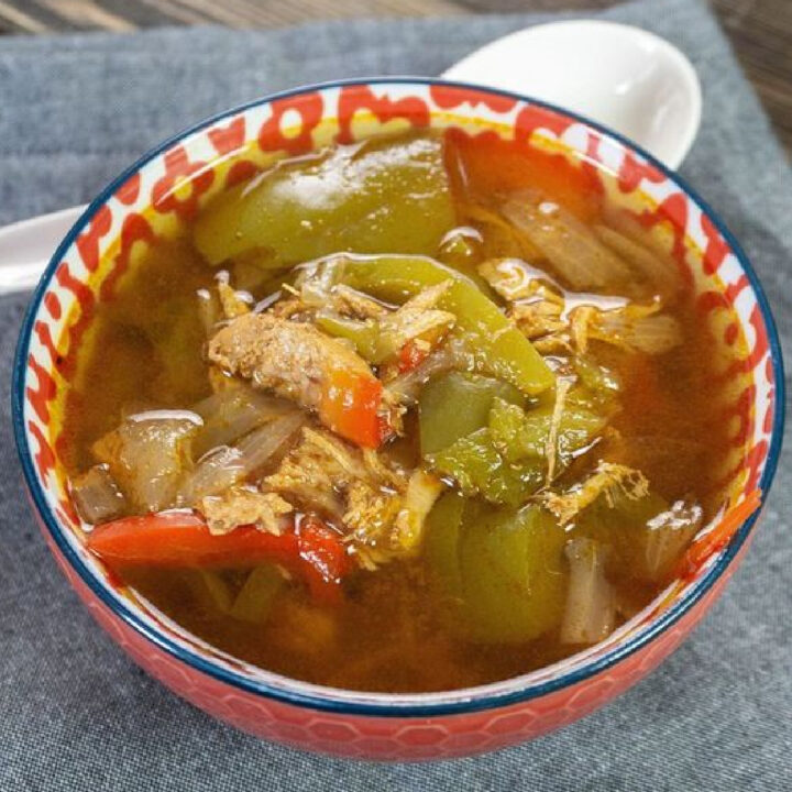 Chicken fajita soup in a bowl served with a spoon.