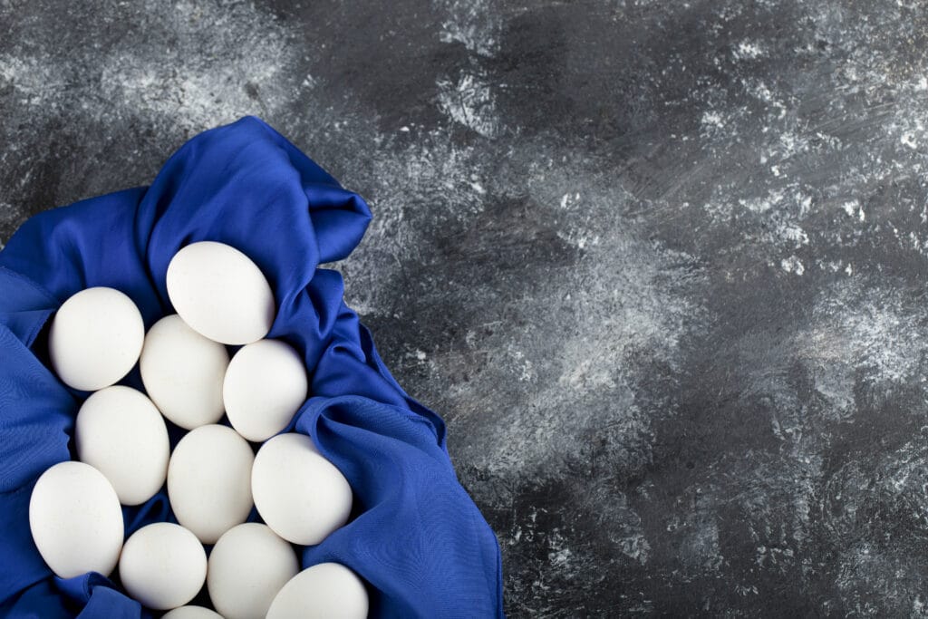 How to Freeze and Use Egg Yolks 4 white raw chicken eggs with blue tablecloth